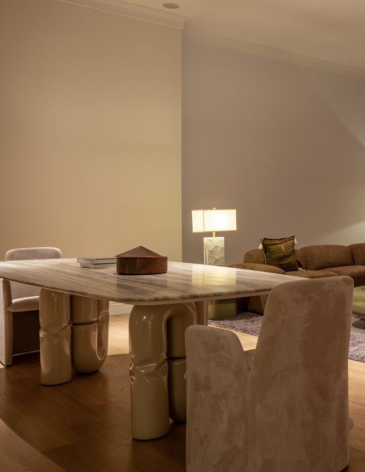 A marble dining table on sculpted lacquer legs with suede dining chairs
